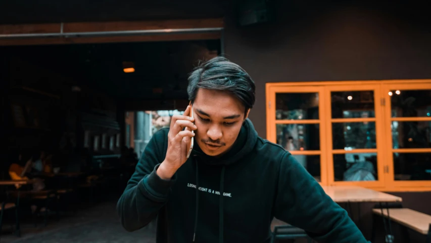 a man talking on a cell phone with his hand to his ear