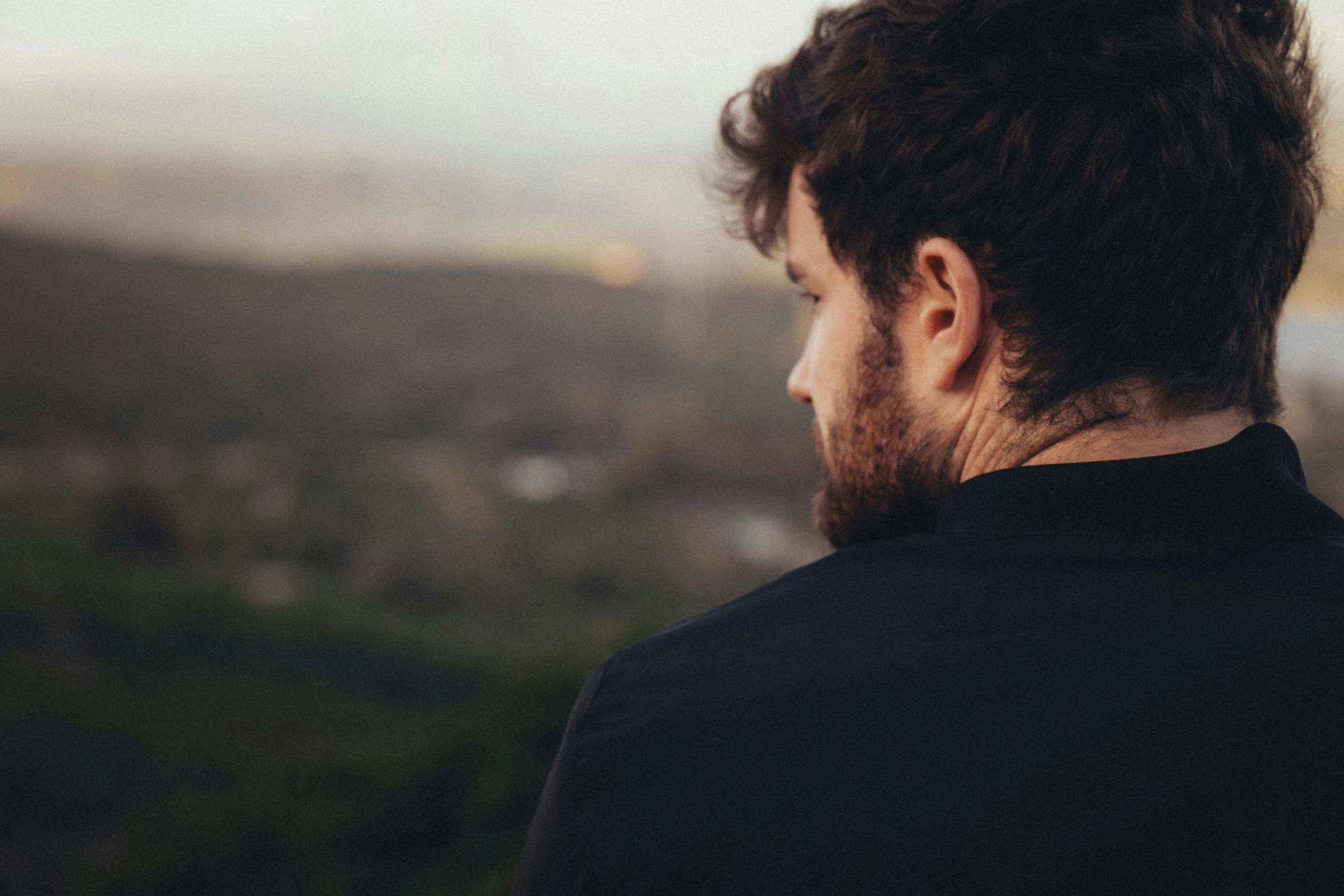 a man with curly hair looking down at the view