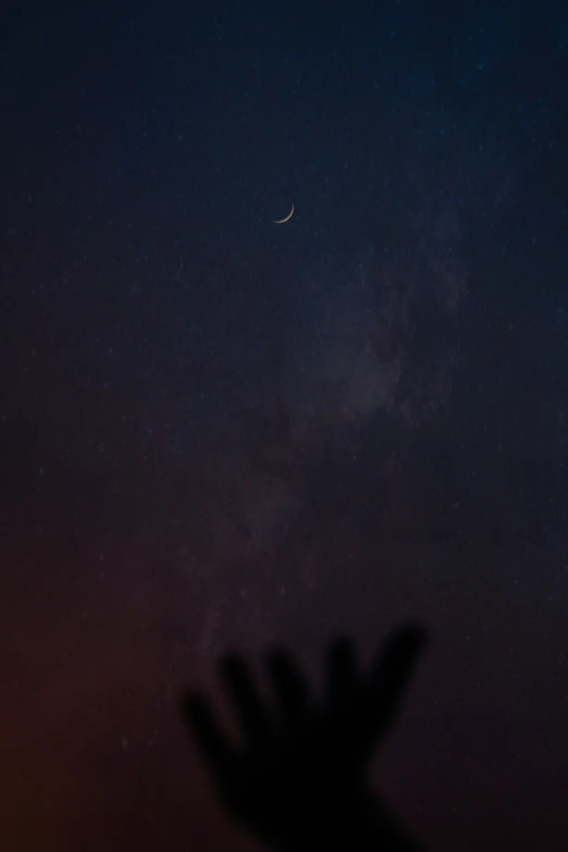 silhouette of hand showing time and moon in night sky