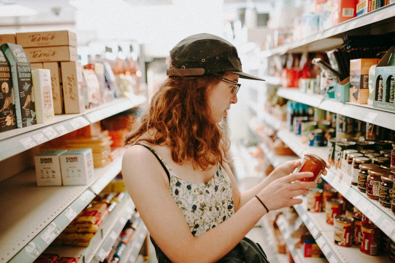 young woman in hat and polka dot blouse shopping in supermarket