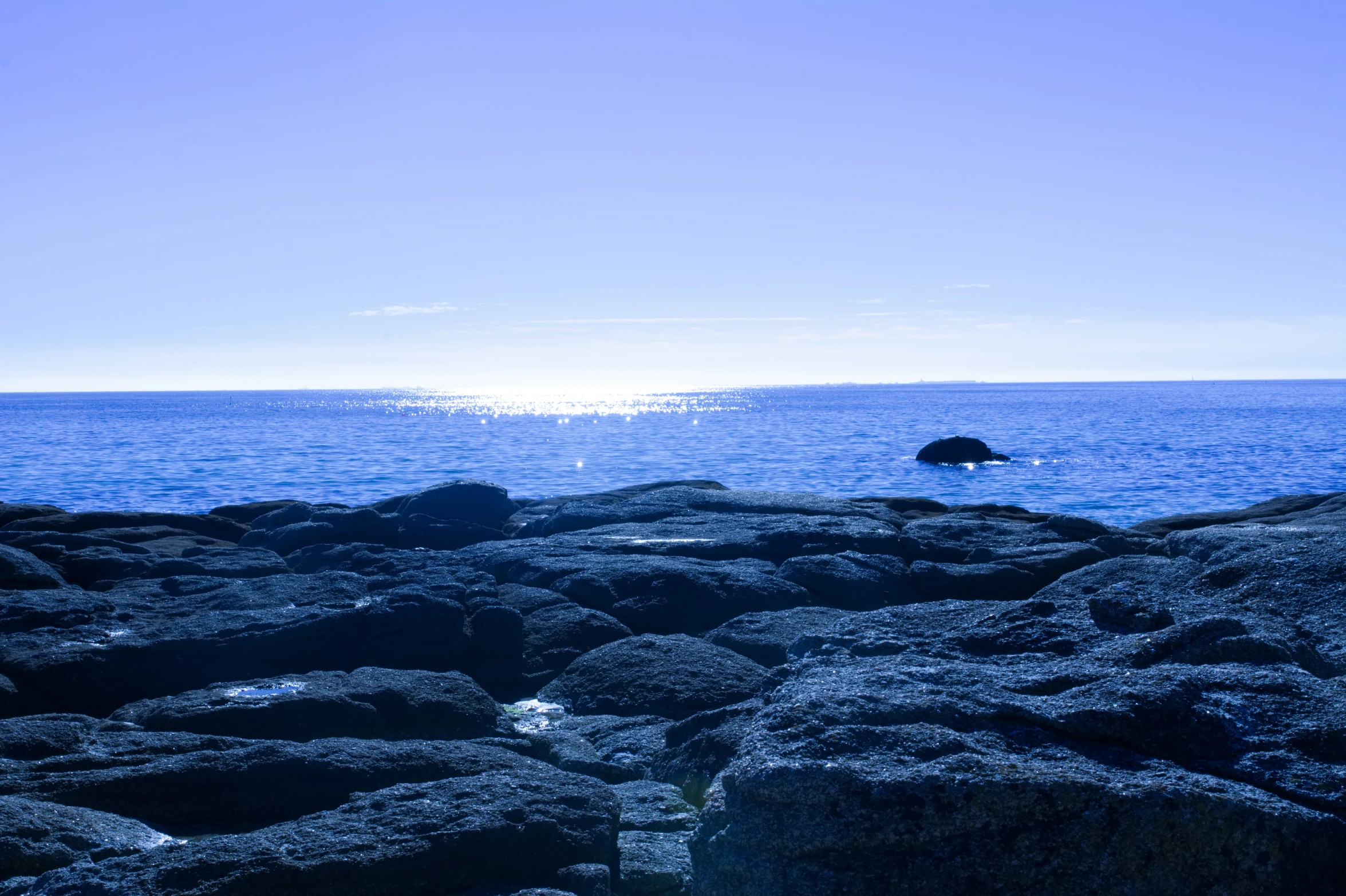 a rocky shore that has some rocks in the foreground