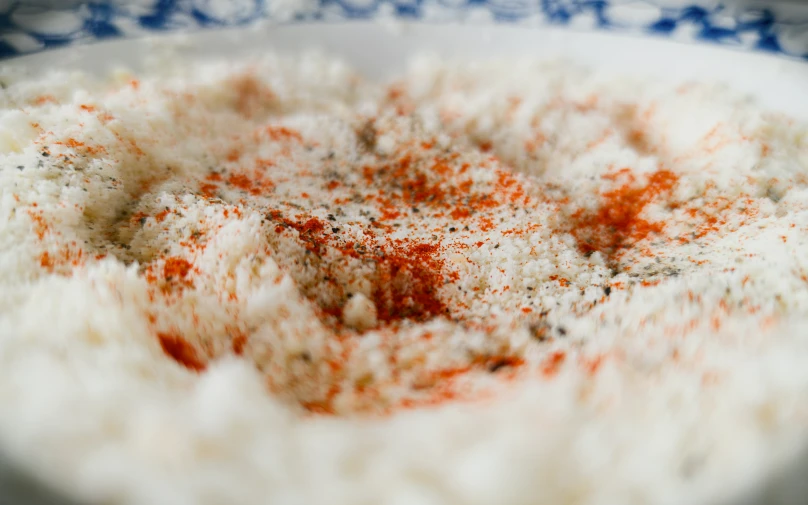 a plate topped with rice and seasoning sitting on a table