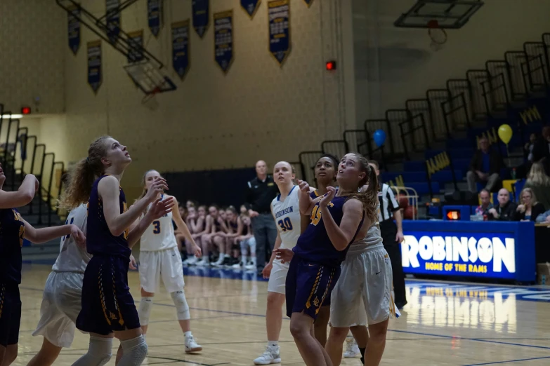 a group of women play basketball on an indoor court