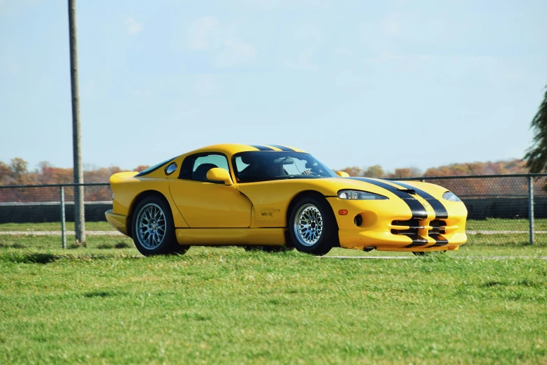 a yellow sports car parked on the grass