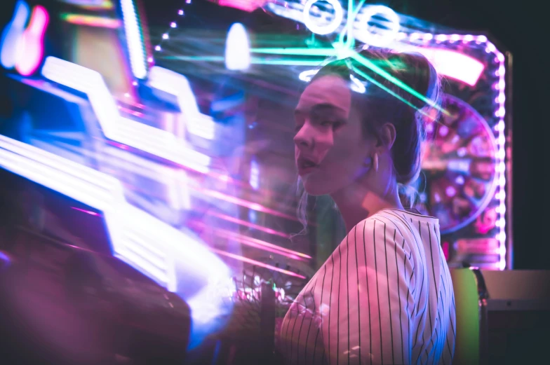 a woman standing near a carnival ride at night