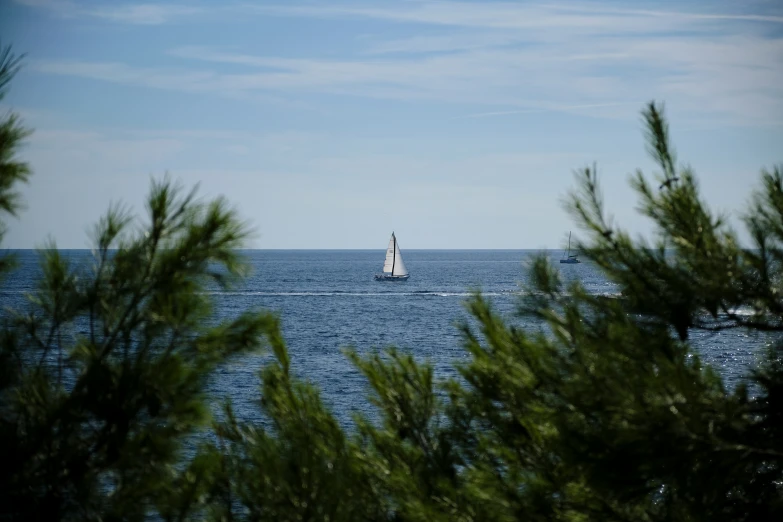 a sail boat is in the middle of an open sea