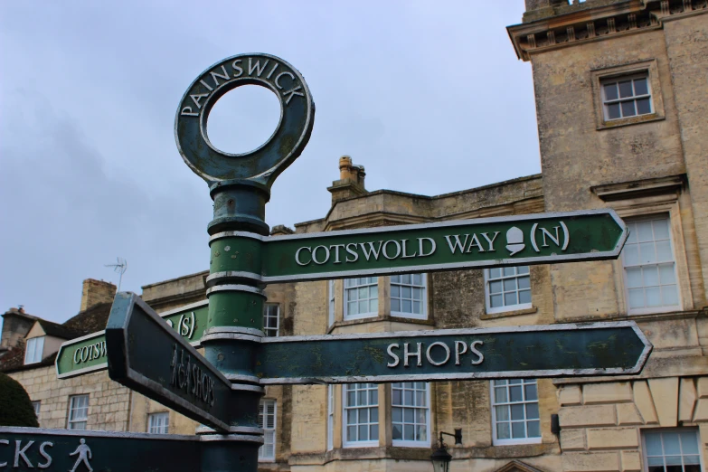 three signs with different font and numbers on it in front of an old building