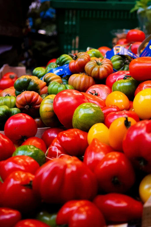 a market stall with tomatoes and bell peppers