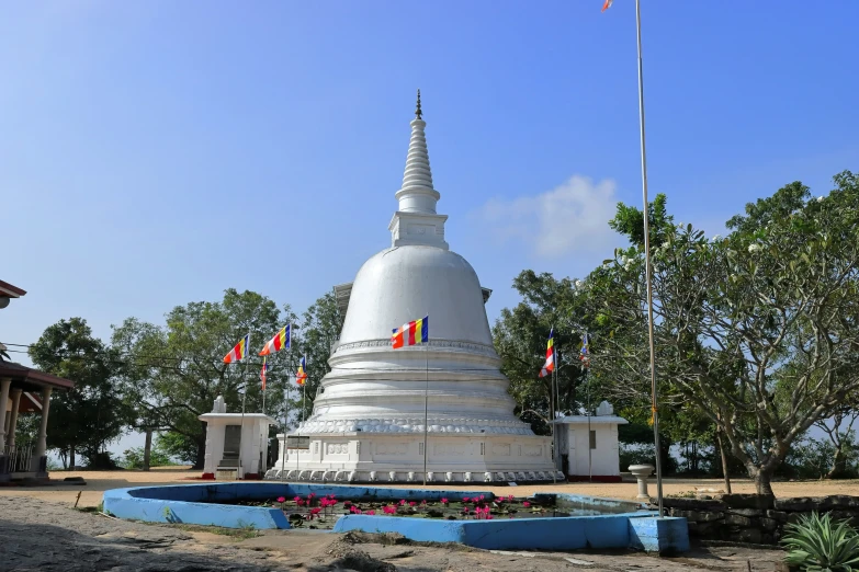 a white statue with flags and other flags on top of it