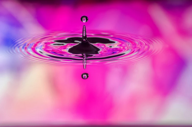a water droplet floating upside down in the middle of a pool of water
