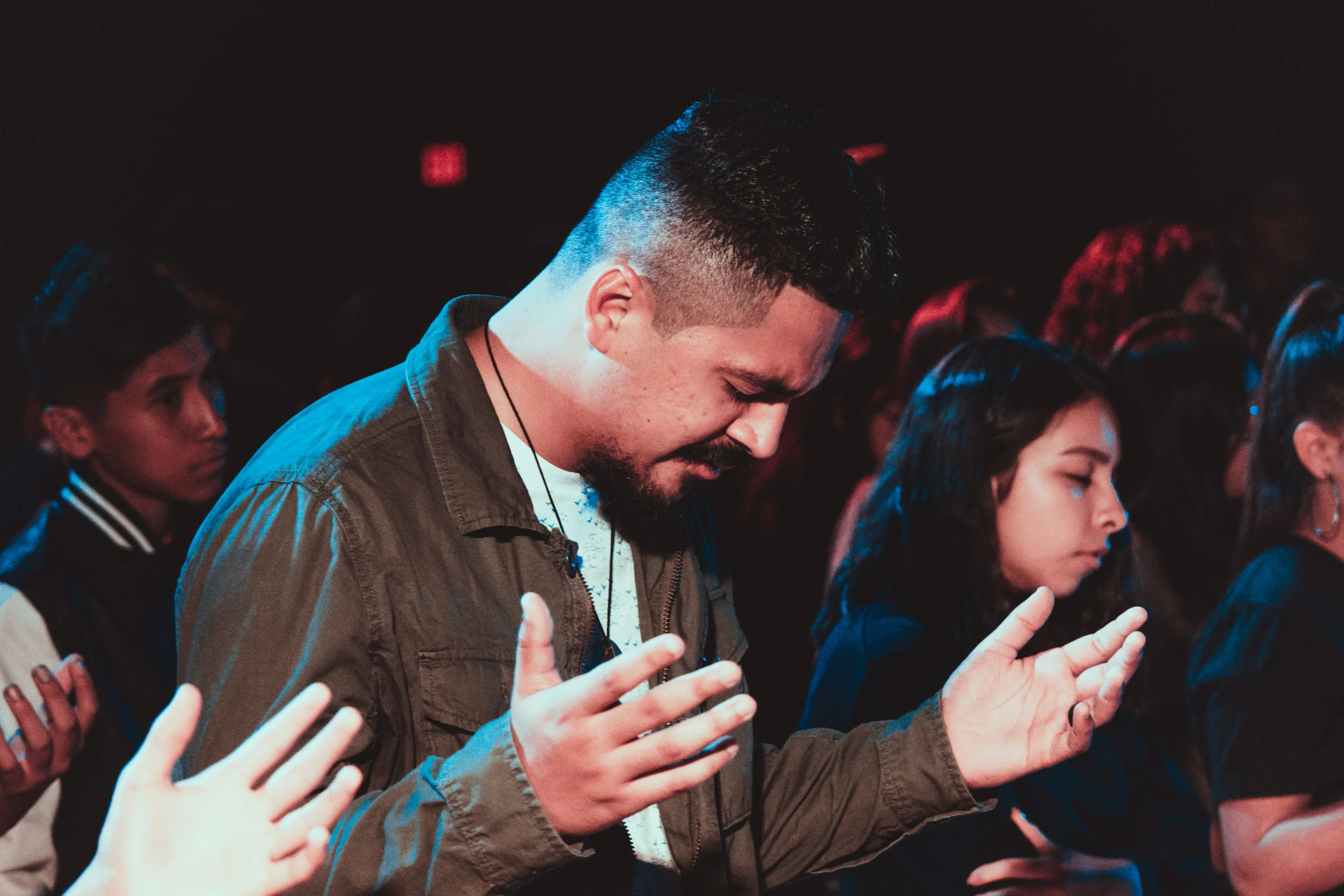 a man kneeling down in front of people praying