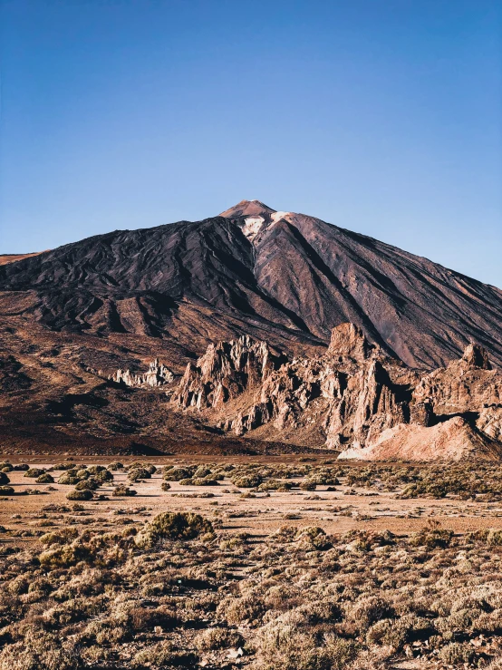 a tall brown mountain with a dirt area below