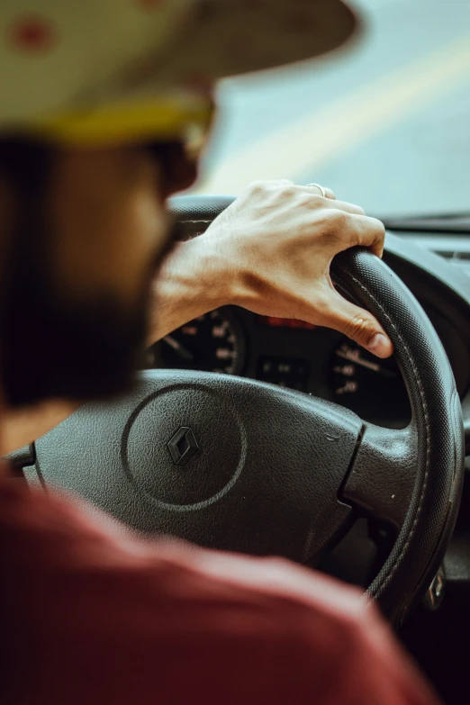 the hands of a driver driving on a highway