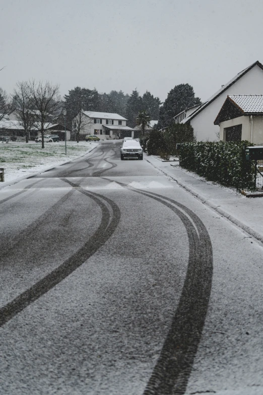 a car is parked on the street with snow on the roof