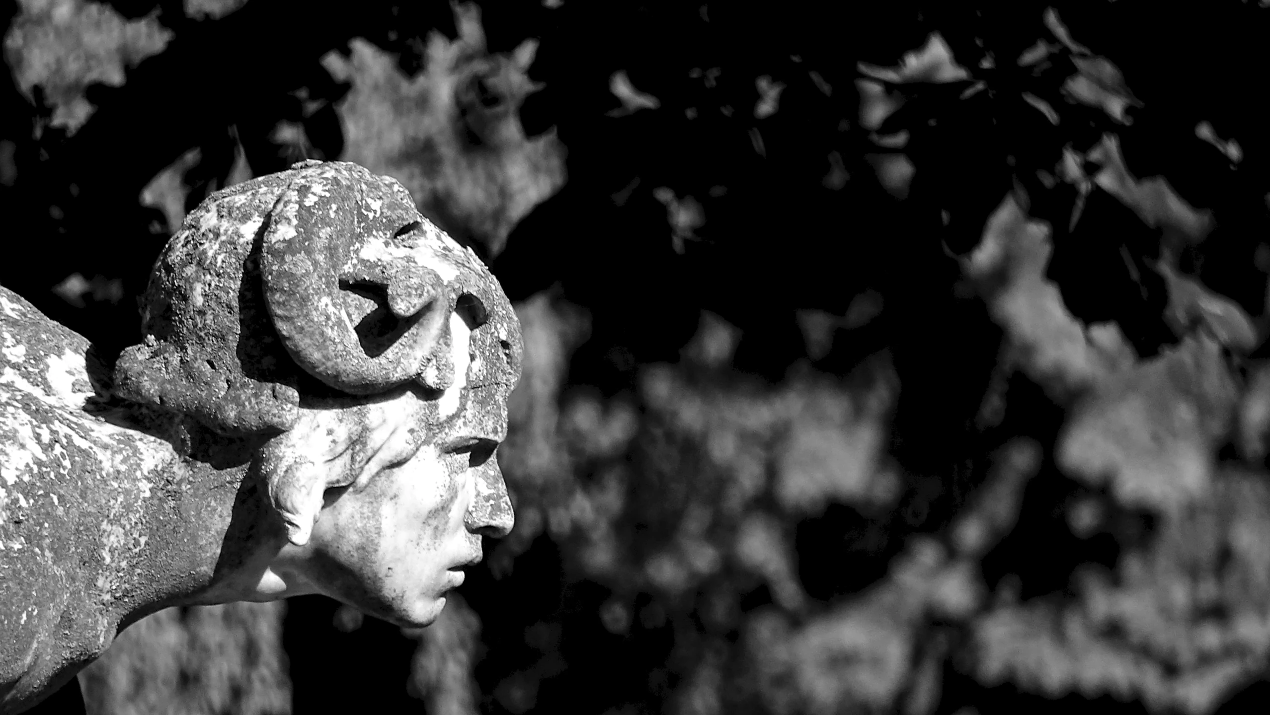 a statue holding a wreath near some trees