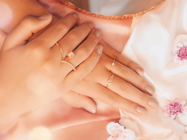 a person wearing rings and pearls on their hand