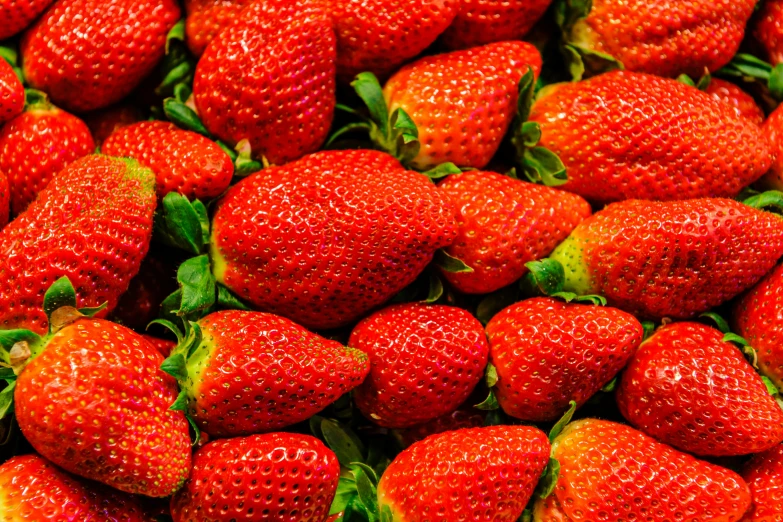 many strawberries grouped together in a close up pattern