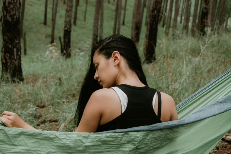 a woman in black top sitting inside a green tent