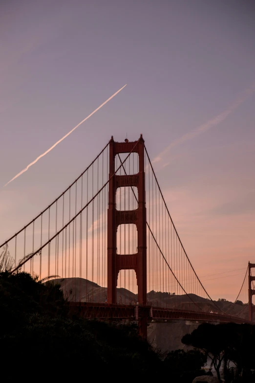 a jet flying above the golden gate bridge