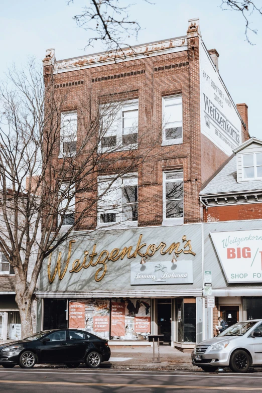 a store front on a street corner with cars parked