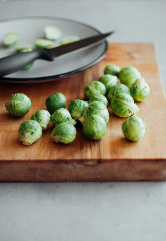 small brussel sprouts next to a large knife