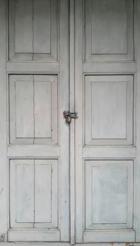 an old white wood door with square and rectangular panels