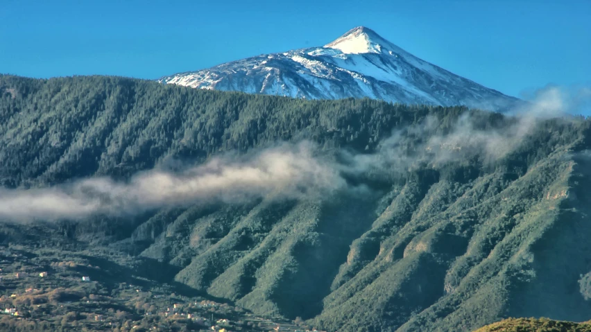 snow capped mountain in distance with valley below