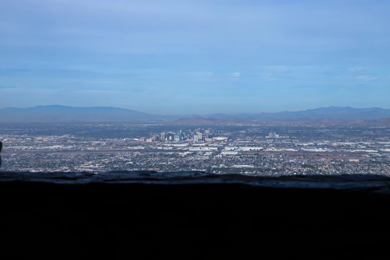 a person sitting on top of a mountain looking over a city