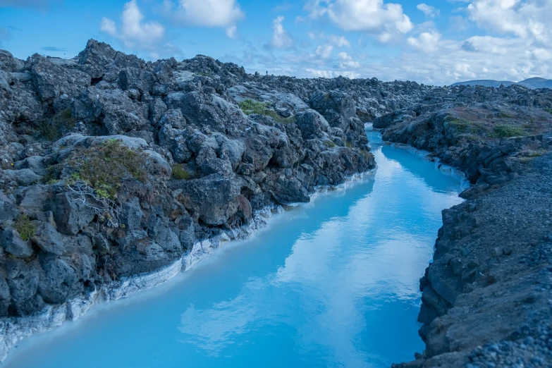 the water is running through the rocks with blue water in it