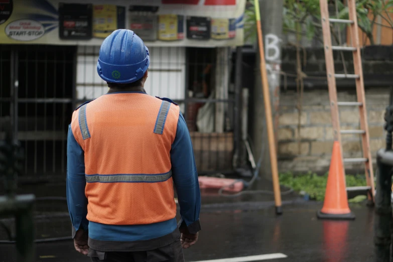 there is a construction worker walking in the rain