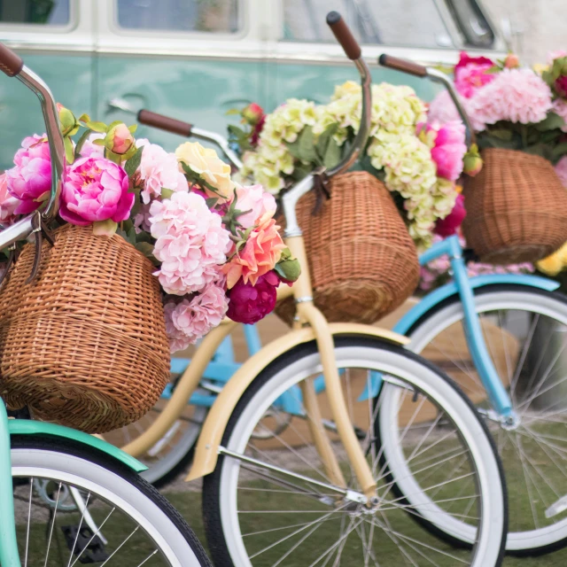 flowers are sitting in baskets on bikes parked