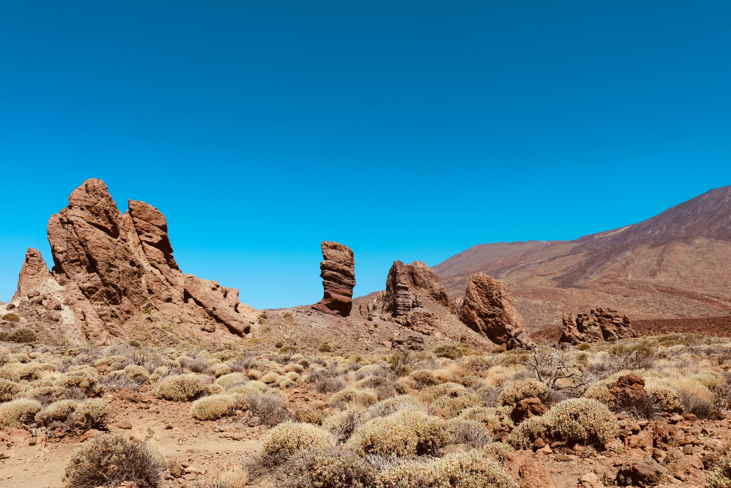 several large rocks are standing in the desert