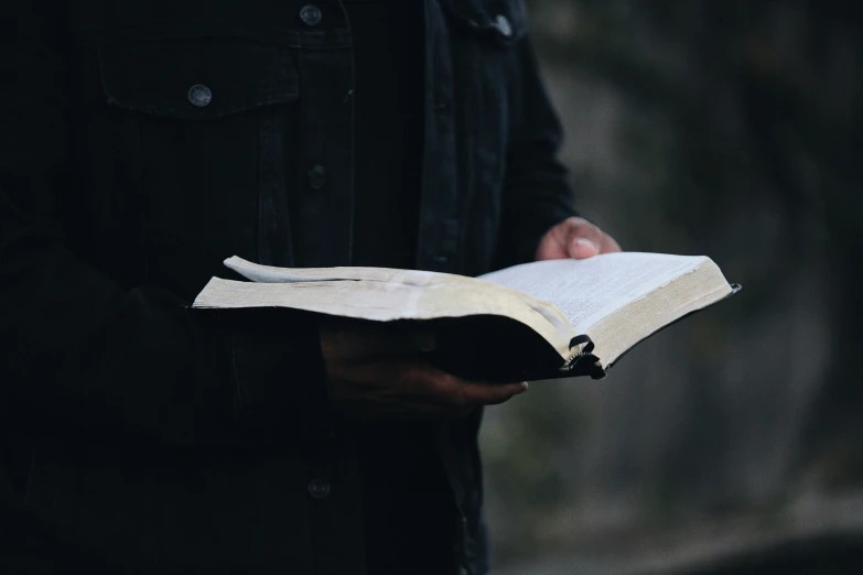 a man holding out a book in his hand