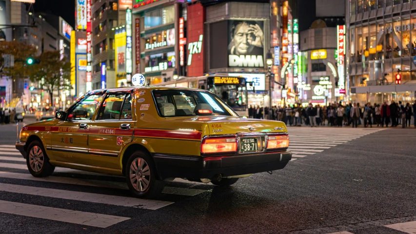 a taxi cab parked at the corner of an intersection in a city