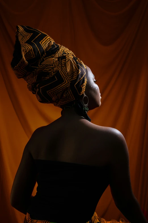 a woman in a brown dress with an orange pattern on her head