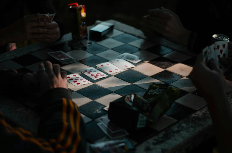 two people sitting at a table with cards