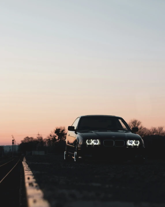 there is a car that is sitting on a railroad