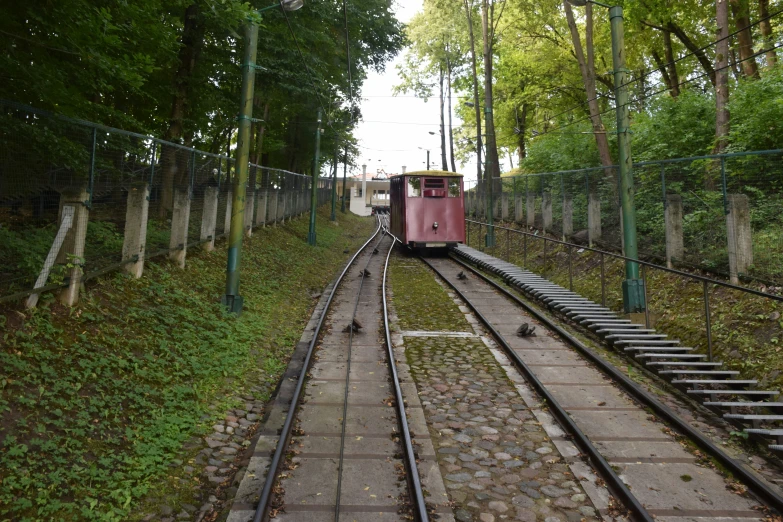 a small red train traveling along a train track