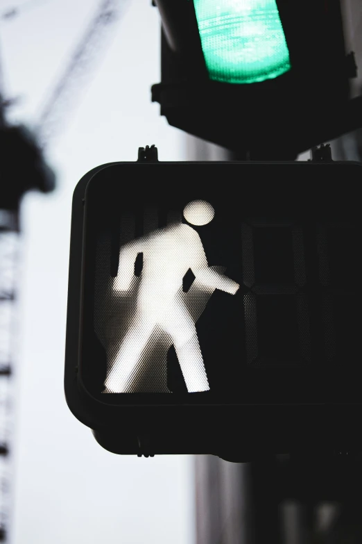 a street light displaying the pedestrian walk signal