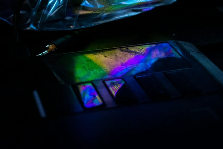 a desk with a laptop and a colorful light on it