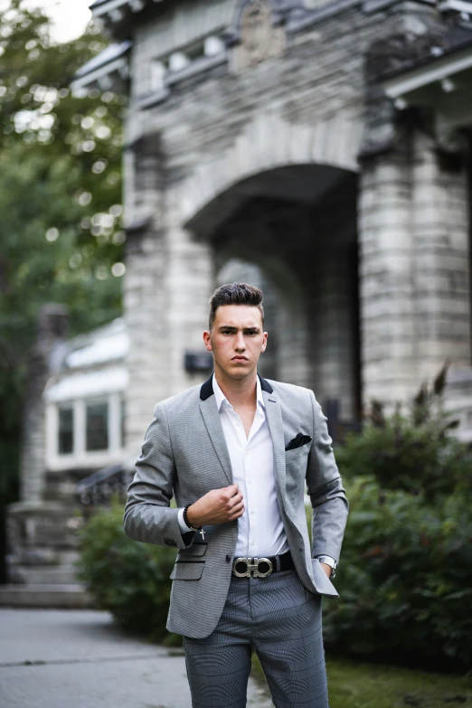 a man in suit and tie leaning on wall