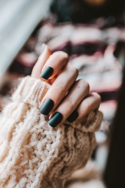 close up of woman's hand wearing an elegant black - toned manicures