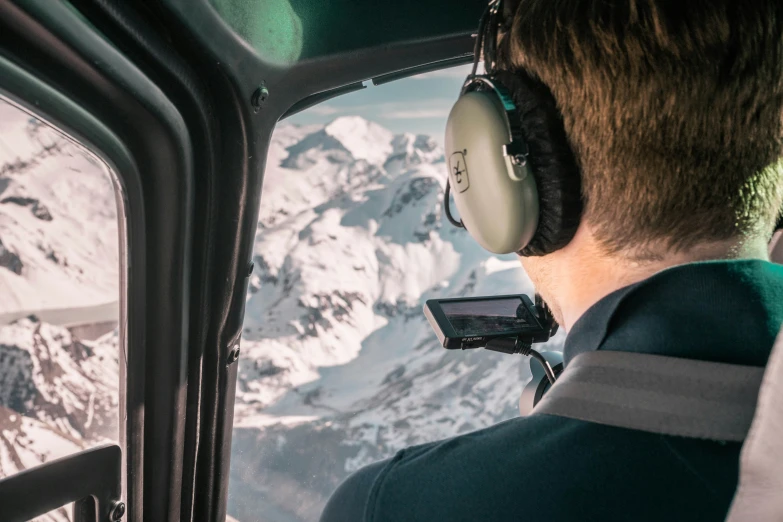 man wearing headphones in the cockpit of a plane