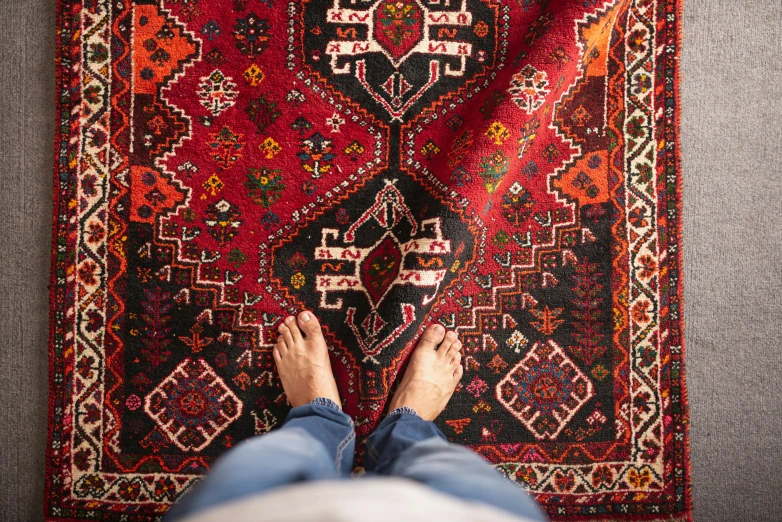 a person lying on a persian rug and reading