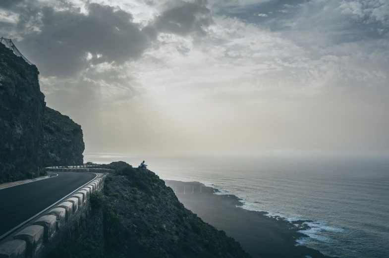 view of a road along the coast with cliffs and water