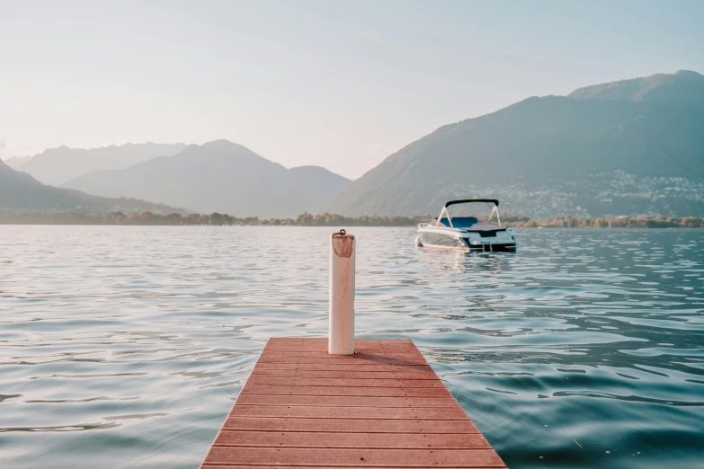 a boat docked on a wooden pier in a lake