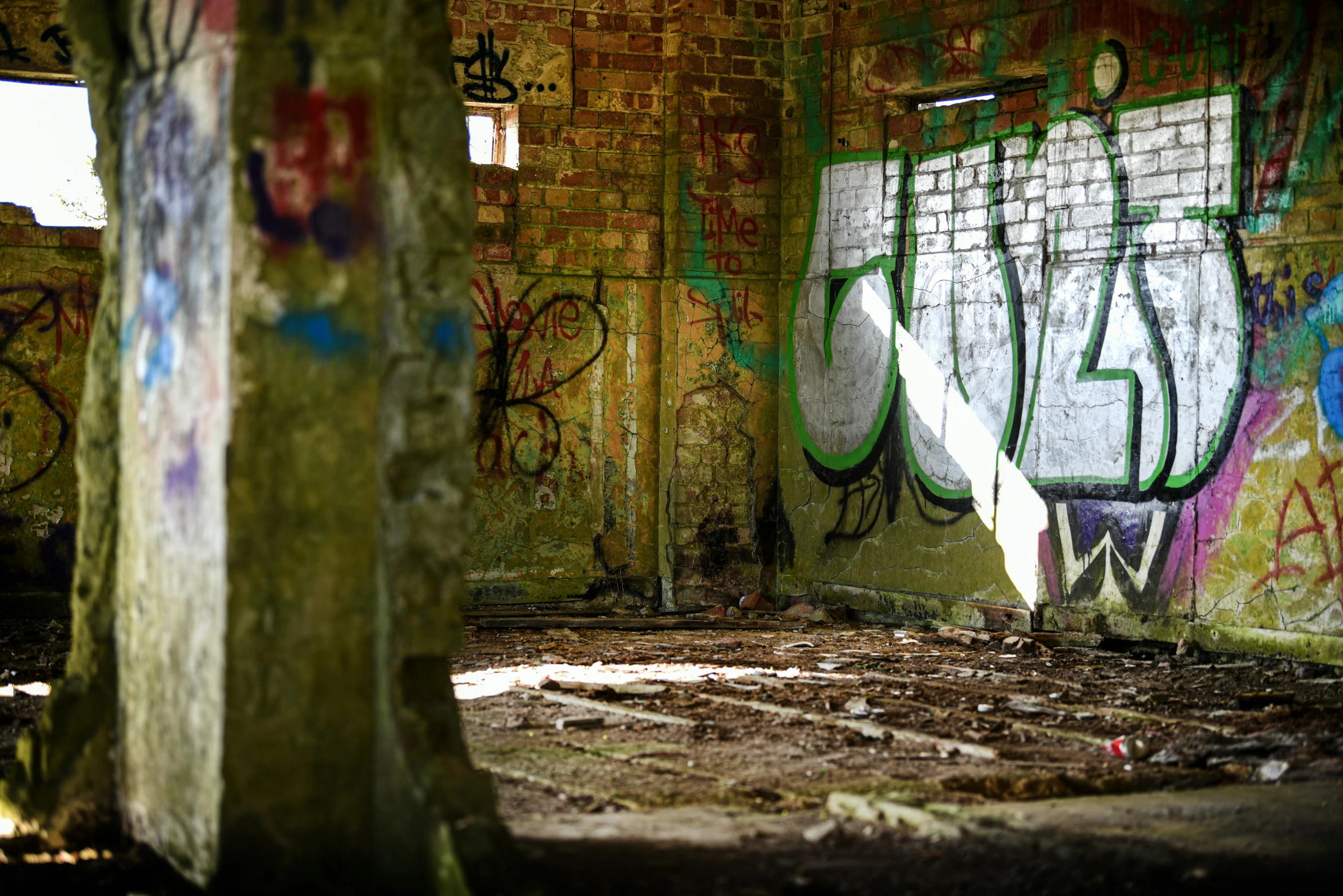 a rotten wall in an old, graffiti - covered building