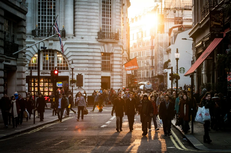 people walking down the street at sunset on a city street