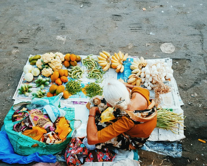 a woman is sitting on the ground with some fruit