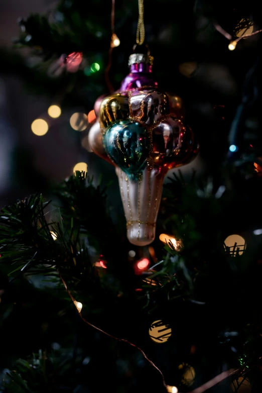 ornaments hanging on a christmas tree covered in lights